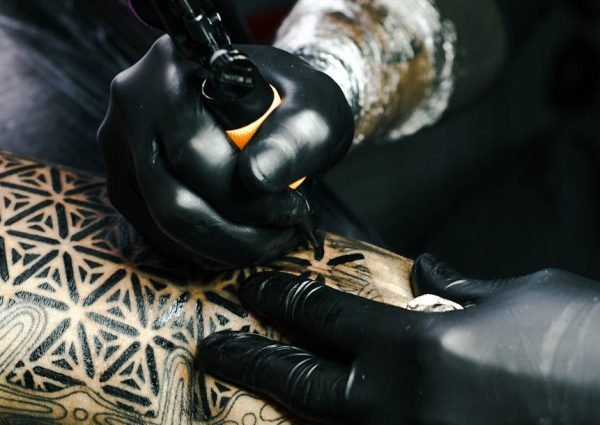 Selective Focus Photography of Tattoo Artist Drawing A Tatoo